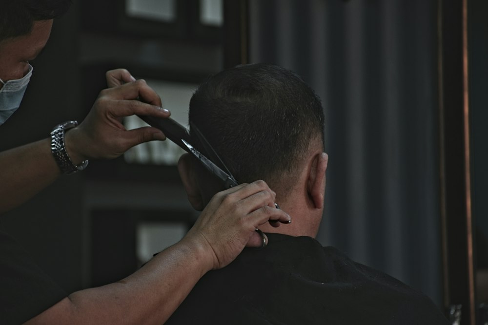 Barbeiro trabalhando em um corte de cabelo. Foto ilustrativa, não retrata a equipe ou o espaço da Nobre.
